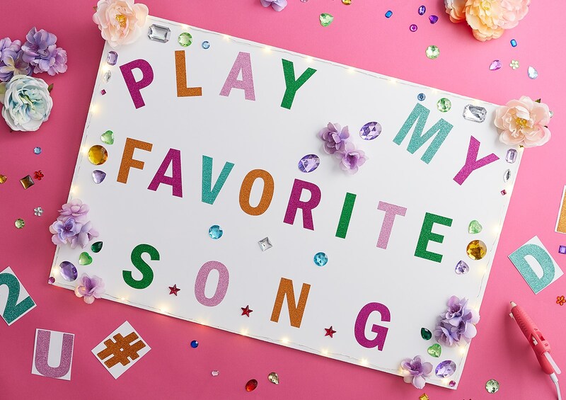 Play my favorite song displayed on white poster sitting on pink background
